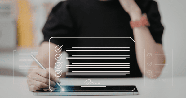 Person signing a digital checklist on a tablet, representing the compliance-without-commitment pattern of Checkbox Adoption in AI rollouts