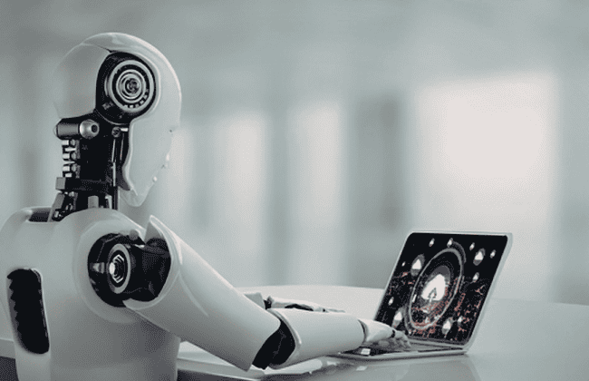 Humanoid robot working on a laptop representing AI replacing human jobs in the workplace