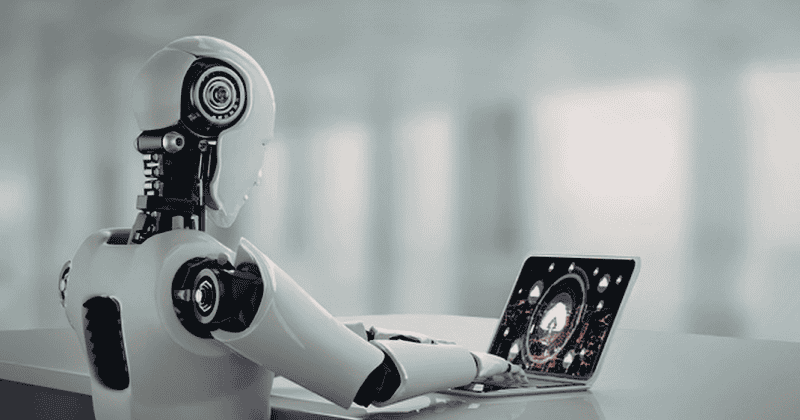 Humanoid robot working on a laptop representing AI replacing human jobs in the workplace